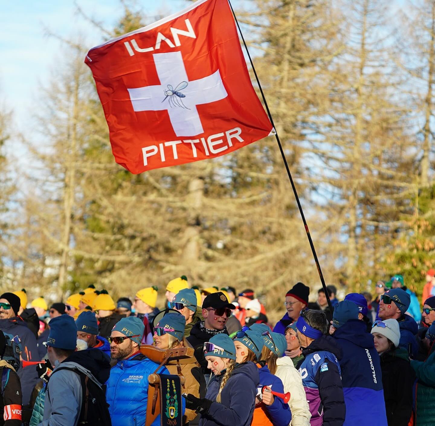 Drapeau suisse aux couleurs d'Ilan Pittier, entouré de supporters